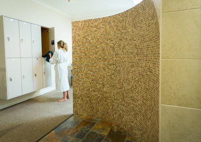 lady in white robe in tiled wet room at spa
